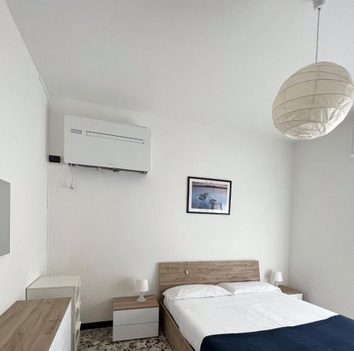 una camera bianca con letto e ventilatore di Appartamento Direttamente sul Mare a Finale Ligure