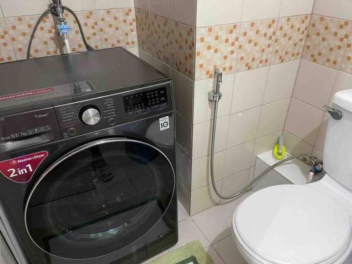 a washing machine in a bathroom with a toilet at Relaxing 1 Bedroom Condo, WIFI, free parking in Manila