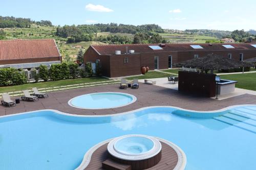uma grande piscina em frente a uma casa em FH Hotel Rural em Felgueiras