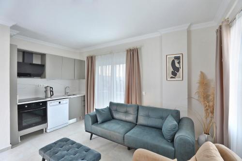 a living room with a blue couch and a kitchen at Lavinya Otel in Golturkbuku