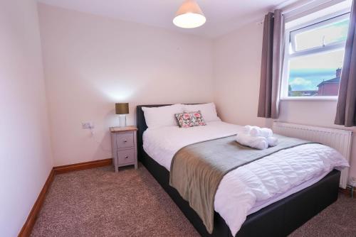 a small bedroom with two beds and a window at Beautiful 2 Bedroom,freeParking L Buzzard in Leighton Buzzard