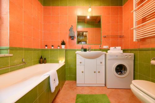 een badkamer met een bad, een wastafel en een wasmachine bij Masuria Warsaw Family in Topolina