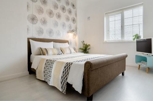 a bedroom with a large bed and a television at Tropical Garden Oasis Rooms in Birmingham