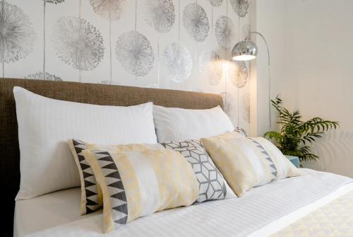 a bed with pillows on it in a bedroom at Tropical Garden Oasis Rooms in Birmingham