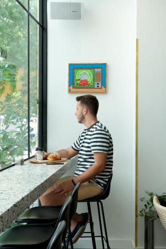 a man sitting at a counter in front of a table at ISLA Tel Aviv in Tel Aviv