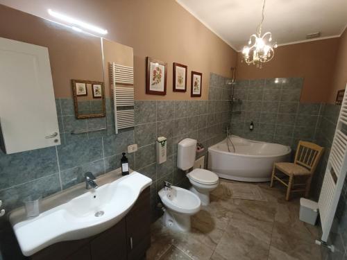 y baño con lavabo, aseo y bañera. en Domus Langhe B&B, en Treiso