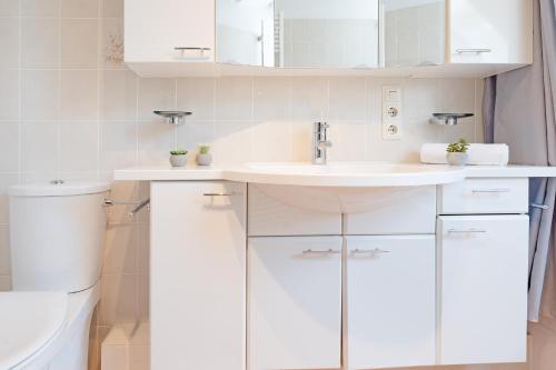 bagno bianco con lavandino e servizi igienici di Haus Eva Mar am Meer Appartement 4 a Timmendorfer Strand