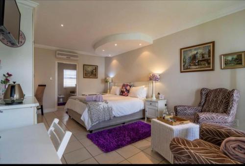 a bedroom with a bed and a living room at Gordon's Beach Lodge in Gordonʼs Bay