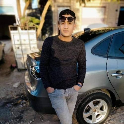 młody chłopiec stojący przed samochodem w obiekcie مصر 