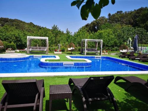 a swimming pool with two chairs and a table at Apartments Villa Subic in Rab