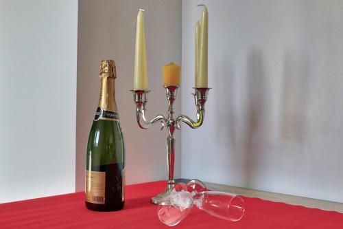 a bottle of champagne and two candles on a table at Ab gite et spa in Benfeld