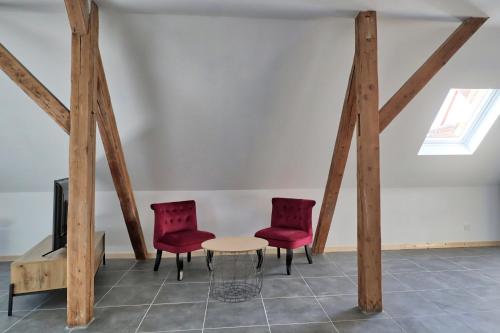 a room with two chairs and a table and a tv at Ab gite et spa in Benfeld