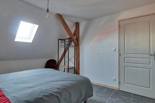 1 dormitorio con cama, escalera y ventana en Ab gite et spa, en Benfeld