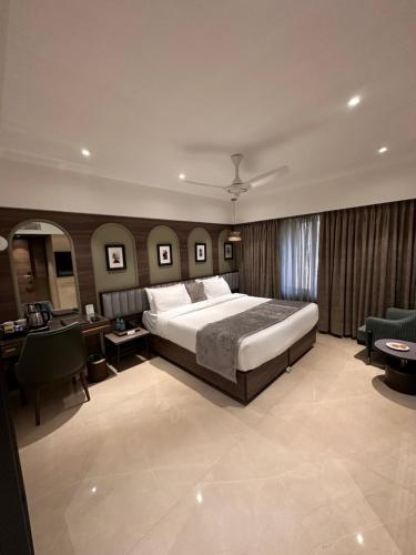 a large bedroom with a large bed and a desk at The International by Tunga in Mumbai