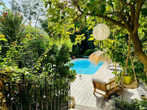 un jardín con piscina, mesa y sillas en Gîte Les Deux Roches, en Le Bar-sur-Loup