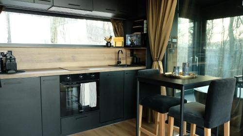 a kitchen with a counter and a table with chairs at ForRest Boutique Cabin in Dunabogdány