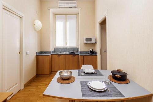a kitchen with a table with plates and bowls on it at Dynasty Suites Downtown Apartments in Turin