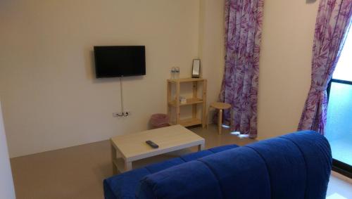 a living room with a blue couch and a tv at B-wei B&B in Hualien City