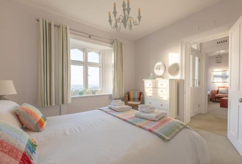 a bedroom with a white bed with towels on it at Gurnard Cottage in Niton