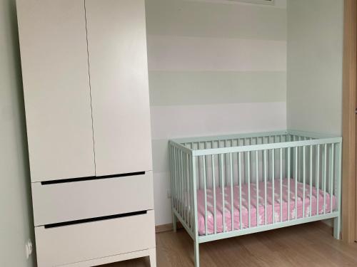 een kinderkamer met een wieg en een witte kast bij Apartament u Uli in Kołobrzeg