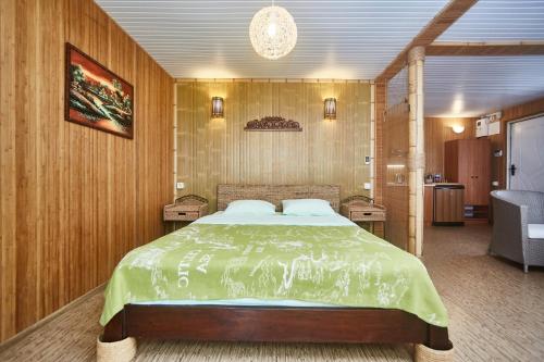 a bedroom with a large bed with wooden walls at Отдых у моря in Nova Dofinivka