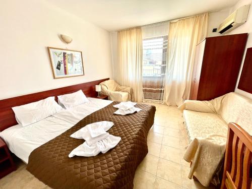 a hotel room with a bed with towels on it at Family Hotel YALTA Свети Влас in Sveti Vlas