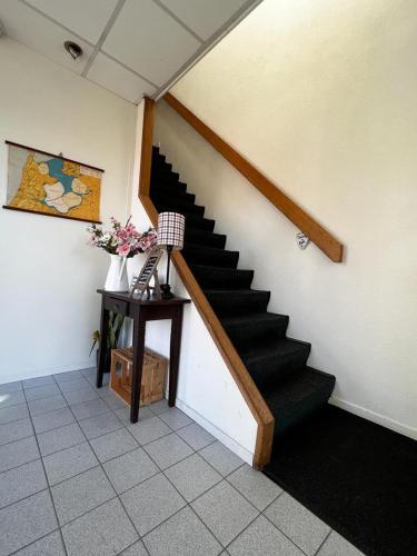 a staircase in a room with a table and flowers at B&B Hartje Spakenburg in Spakenburg