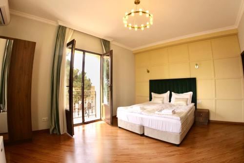 a bedroom with a bed and a large window at Phazisi Hotel in Tbilisi City
