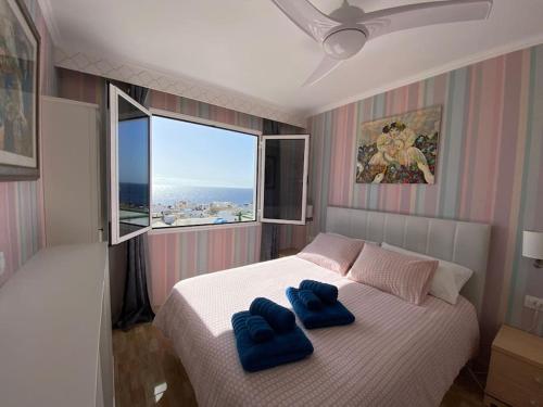 um quarto com uma cama com duas toalhas azuis em BUENAVISTA em Puerto del Carmen