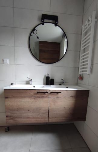 a bathroom with a sink and a mirror at Apartamenty Wisła Krzywa 8, wanna z hydromasażem, basen zewnętrzny in Wisła