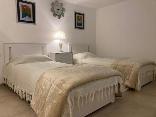 1 dormitorio con 2 camas y mesita de noche con lámpara en Tencarola B & B, en Tencarola