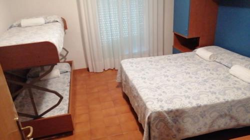 a small bedroom with two beds and a mirror at Hotel Trifoglio in Lido di Jesolo