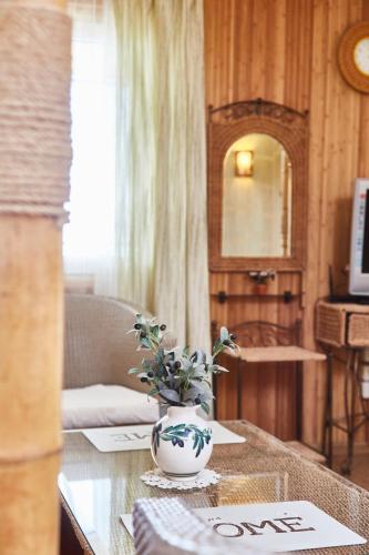 a room with a table with a vase with flowers on it at Отдых у моря in Nova Dofinivka