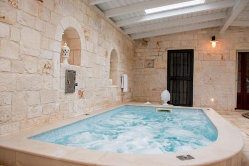 a large bath tub in a stone walled room at Micele Holiday Houses in Locorotondo