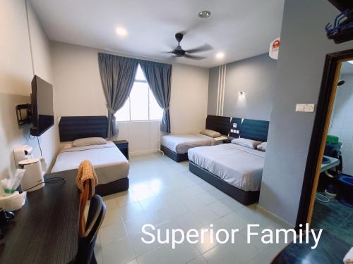 a hotel room with two beds and a mirror at Winton Hotel in Mentekab