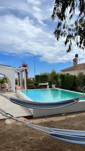 een groot zwembad met een boot in een tuin bij Casa Eucaliptus in L'Eucaliptus