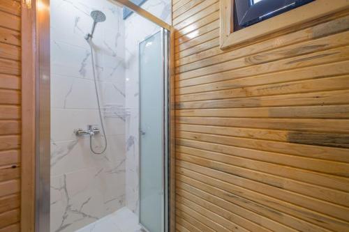 a bathroom with a shower with a glass door at Hidden Bungalow in Kaş