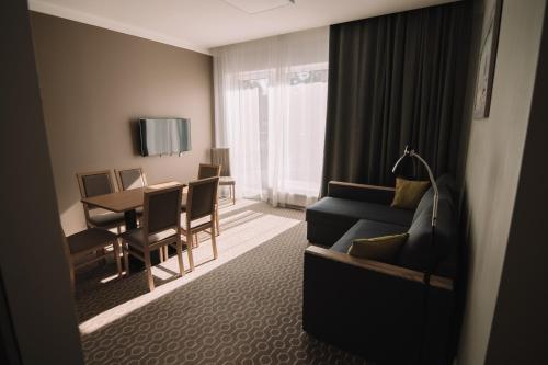 a living room with a couch and a dining table at Merepargi ApartHotel & Cafe in Narva-Jõesuu