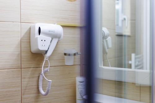 a phone is hanging on a wall in a bathroom at Hotel Central - Baile Olanesti in Băile Olăneşti