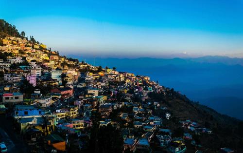 a town on top of a hill with houses at Forest Cabin Bugyal Stays in Pauri