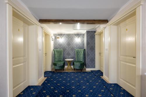 a hallway with two green chairs and a table at CASA DE LA MUNTE in Frumosu