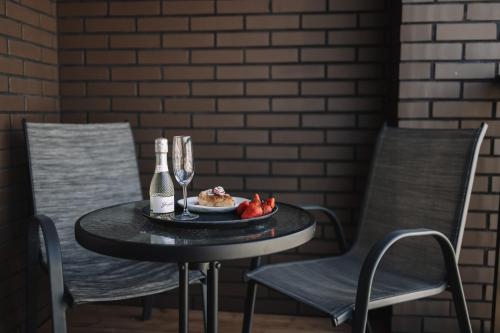 a table with a plate of food and a bottle of wine at Merepargi ApartHotel & Cafe in Narva-Jõesuu