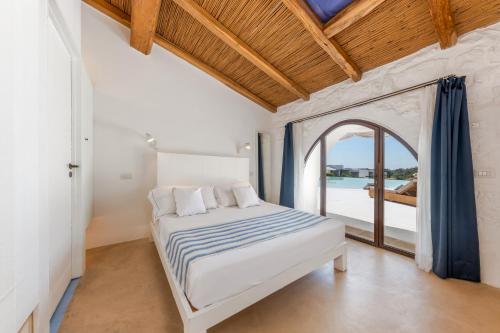 a bedroom with a bed and a large window at Masseria Samenti in Torre Suda