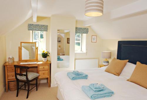 um quarto com uma cama, uma secretária e um espelho em Orchard Cottage Monmouthshire 