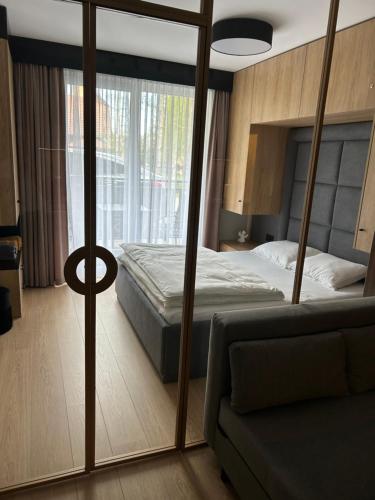 ein Schlafzimmer mit einem Bett und einer Couch in der Unterkunft Lazurowy Apartament in Łeba
