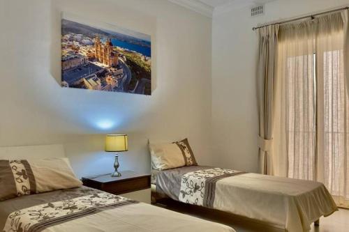 a hotel room with two beds and a window at sea view apartment on Sliema Promenade in Sliema