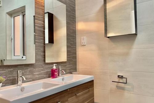 a bathroom with a sink and two mirrors at sea view apartment on Sliema Promenade in Sliema