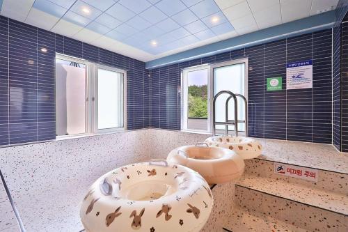 uma grande casa de banho com dois lavatórios e dois espelhos em Doan Kids Hotel Yangsan em Yangsan
