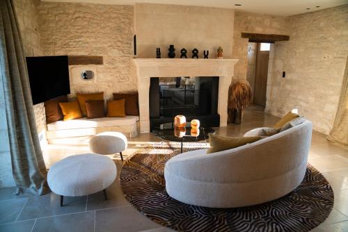 sala de estar con sofá blanco y chimenea en Domaine Truffier du Grand Merlhiot en Savignac-les-Églises