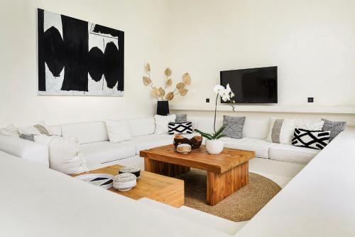 a living room with a white couch and a coffee table at Casa Umalas Villa by Betterplace in Canggu